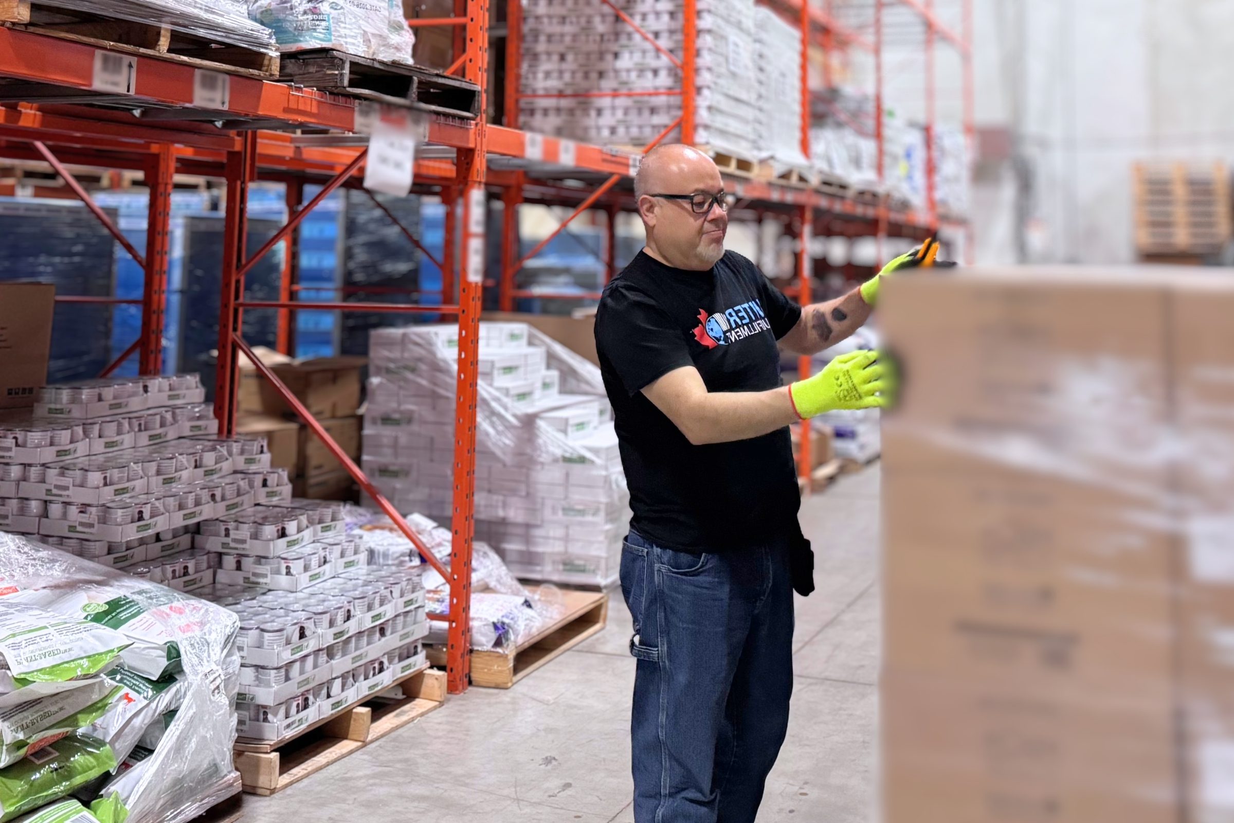 Automated conveyor system sorting e-commerce fulfillment in Canada packages inside a modern multi-facility warehouse.